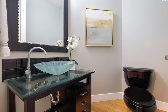 bathroom with hardwood / wood-style flooring, vanity, and toilet