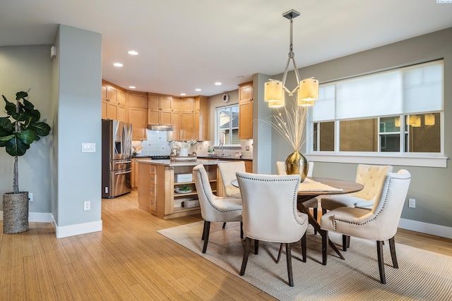 dining space with sink and light wood-type flooring