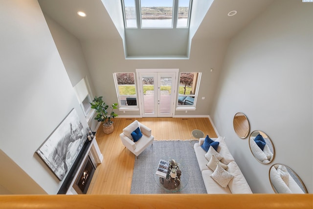 living room with hardwood / wood-style flooring, french doors, and a towering ceiling