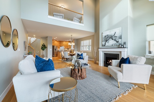 living room featuring a high ceiling and light hardwood / wood-style floors