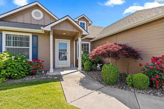 106 Muirfield Ln, Pasco, WA 99301 - doorway to property with board and batten siding, a shingled roof, and a yard