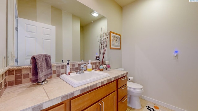 half bathroom with tasteful backsplash, tile patterned flooring, vanity, baseboards, and toilet