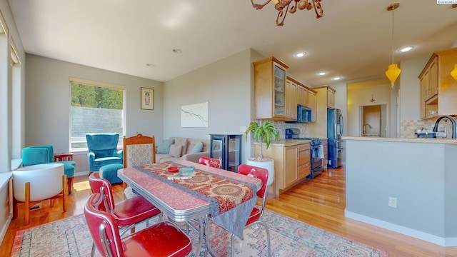 dining area featuring light wood-type flooring, recessed lighting, and baseboards