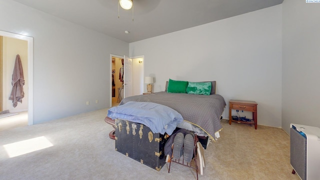 bedroom featuring carpet flooring, ceiling fan, and a walk in closet