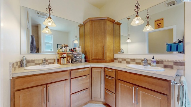 bathroom with a sink, double vanity, and visible vents