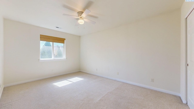 spare room featuring baseboards, visible vents, and light carpet