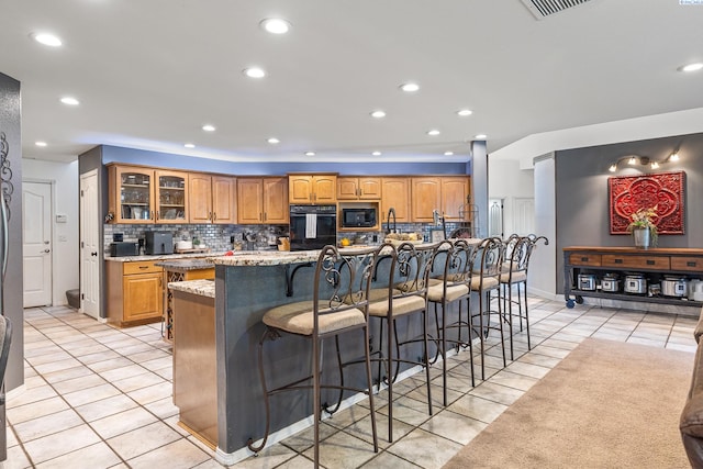 4107 Mojave Ct, Pasco, WA 99301 - kitchen with black appliances, light tile patterned floors, backsplash, a breakfast bar area, and recessed lighting