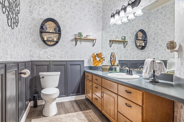4107 Mojave Ct, Pasco, WA 99301 - bathroom featuring wallpapered walls, toilet, wood finished floors, vanity, and wainscoting