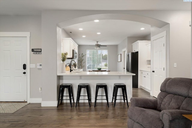 5 Hollyhock Ct, Pasco, WA 99301 - kitchen featuring arched walkways, open floor plan, freestanding refrigerator, a breakfast bar area, and a peninsula