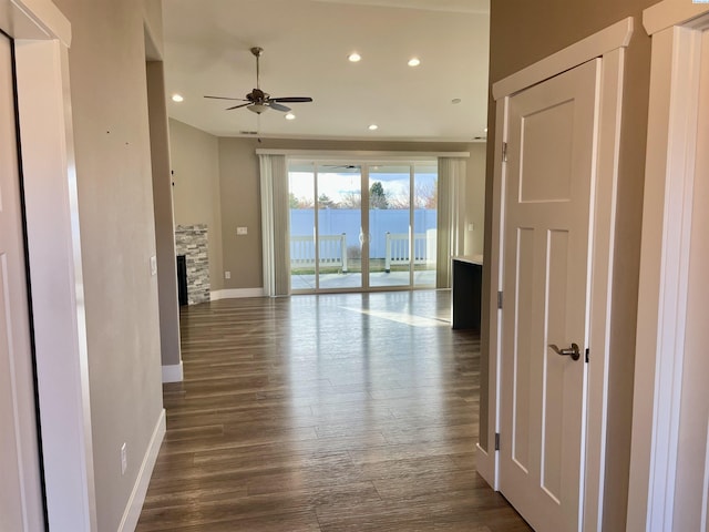 corridor with dark wood-style floors, recessed lighting, and baseboards