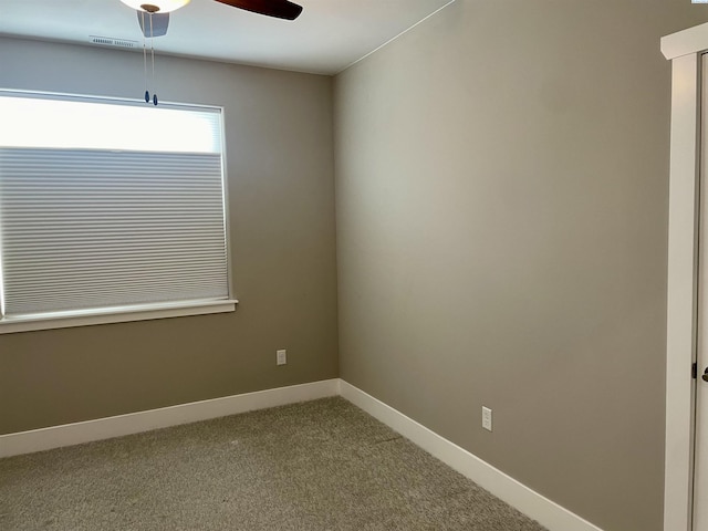 empty room with visible vents, baseboards, carpet floors, and ceiling fan