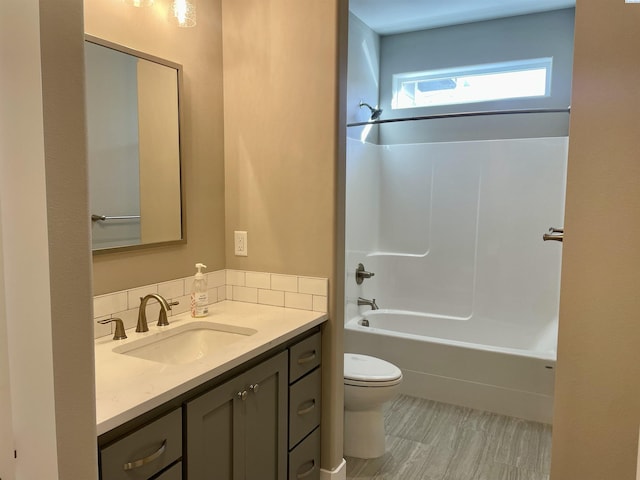 bathroom featuring toilet, bathtub / shower combination, and vanity