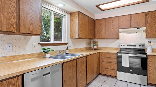 5456 Fern Loop, West Richland, WA 99352 - kitchen with stainless steel appliances, under cabinet range hood, light countertops, and brown cabinetry