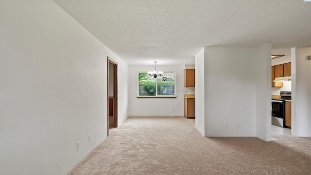 5456 Fern Loop, West Richland, WA 99352 - empty room featuring light carpet, a chandelier, and a textured ceiling