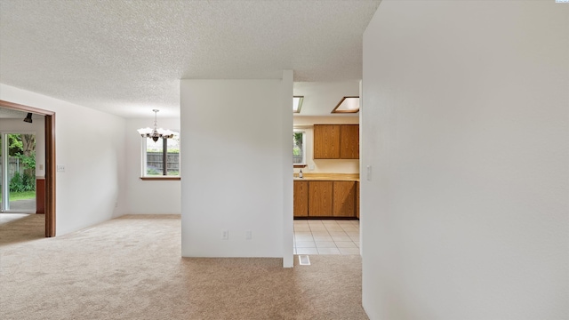 5456 Fern Loop, West Richland, WA 99352 - spare room with light colored carpet, a chandelier, healthy amount of natural light, and a textured ceiling
