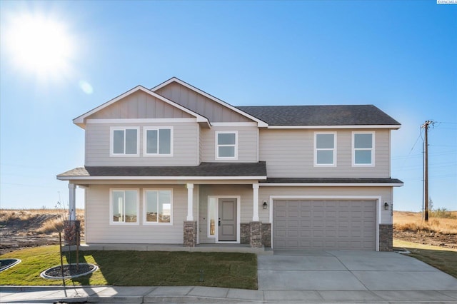 craftsman house featuring a garage and a front lawn