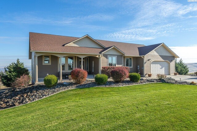 ranch-style home with a garage, a front lawn, and covered porch