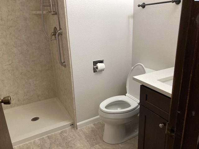 bathroom with a stall shower, vanity, and toilet