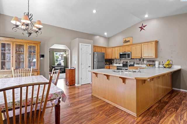 kitchen featuring appliances with stainless steel finishes, dark hardwood / wood-style flooring, kitchen peninsula, and light brown cabinets