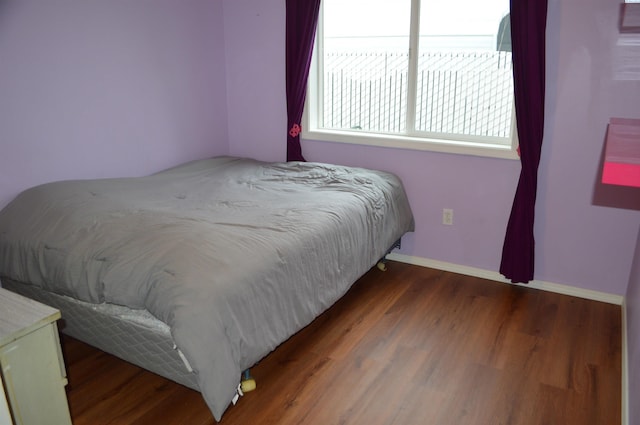 bedroom with dark wood-type flooring