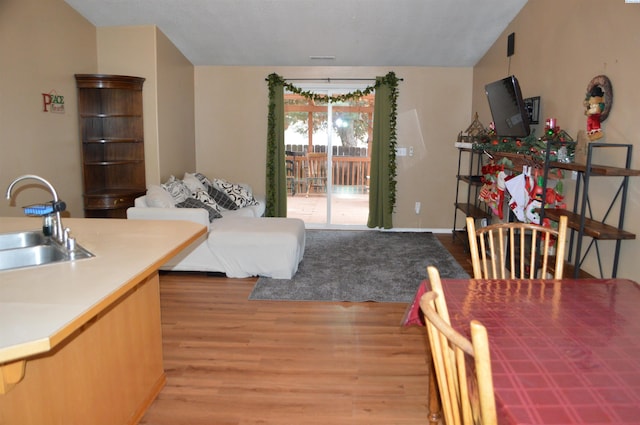 bedroom with light hardwood / wood-style flooring, sink, access to outside, and lofted ceiling