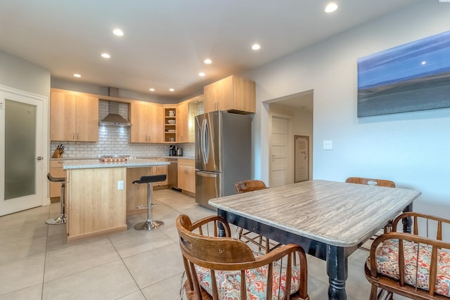 kitchen featuring recessed lighting, stainless steel appliances, light brown cabinetry, a kitchen island, and light countertops