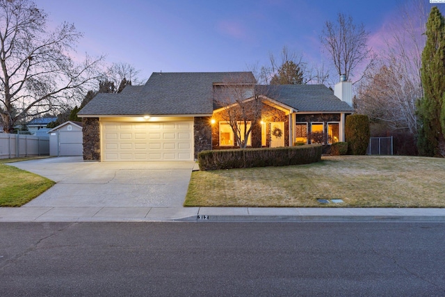 view of front facade featuring a chimney, a lawn, an attached garage, fence, and driveway