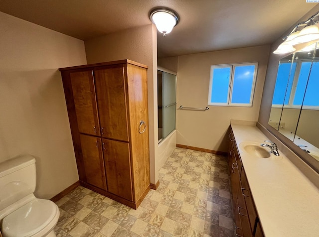 bathroom featuring shower / bath combination with glass door, vanity, toilet, and baseboards