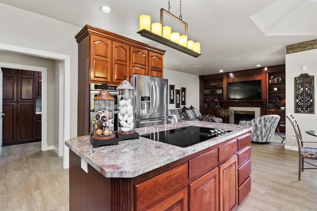 kitchen featuring hanging light fixtures, light hardwood / wood-style flooring, a kitchen island, stainless steel appliances, and light stone countertops