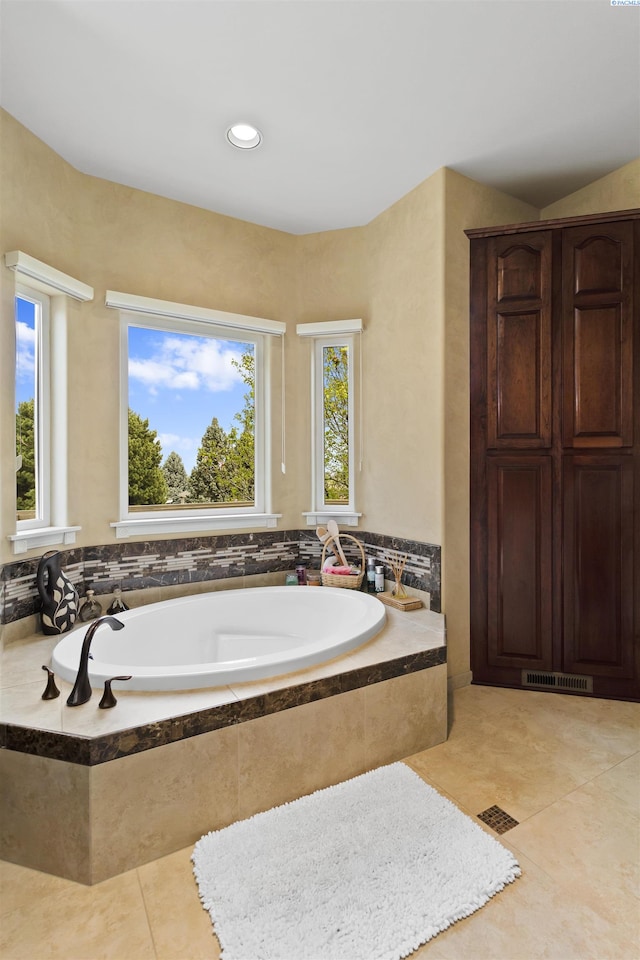 bathroom featuring tiled tub and tile patterned floors