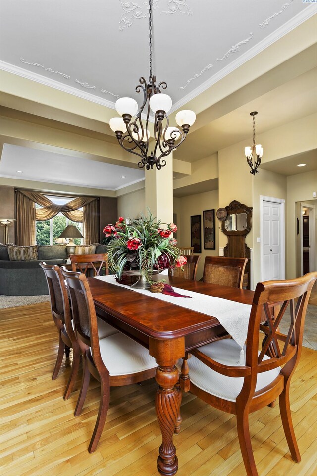 dining space with crown molding, a chandelier, and light wood-type flooring