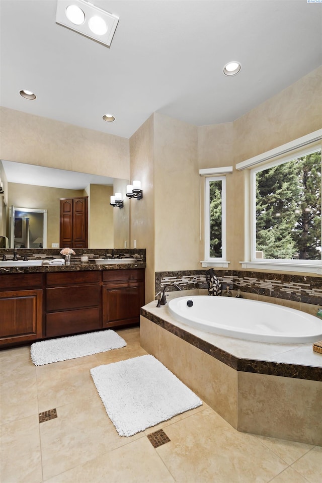 bathroom featuring vanity, tile patterned flooring, and tiled bath