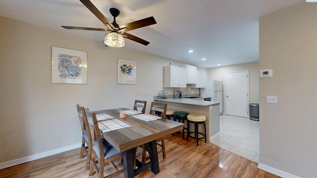 dining room with baseboards, recessed lighting, ceiling fan, and light wood-style flooring