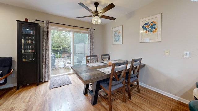 dining room featuring ceiling fan, baseboards, and light wood-style floors