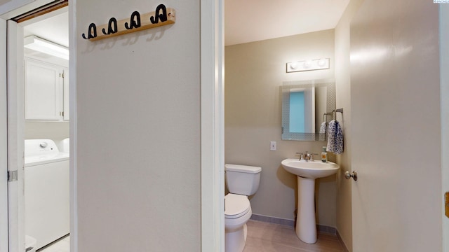 half bathroom with baseboards, a sink, and toilet