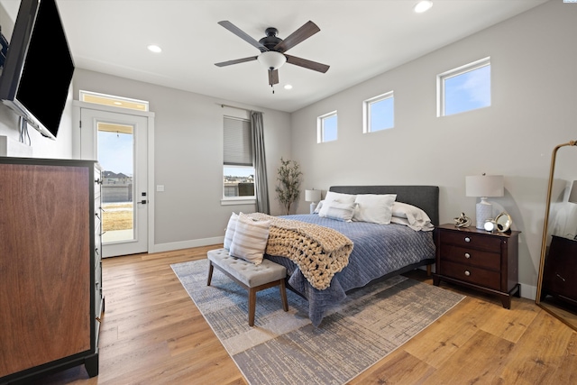 bedroom with ceiling fan, access to exterior, multiple windows, and light wood-type flooring