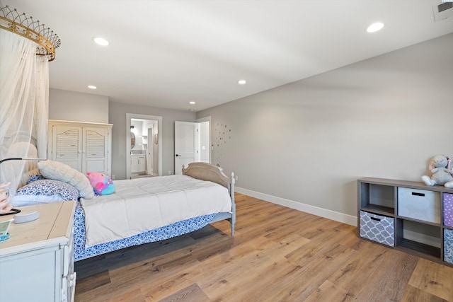 bedroom featuring light hardwood / wood-style flooring and ensuite bathroom