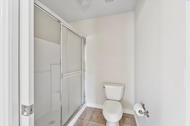 full bath featuring a stall shower, toilet, baseboards, and tile patterned floors