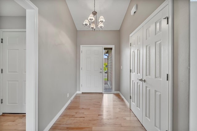 entryway with a chandelier, light wood-style floors, and baseboards