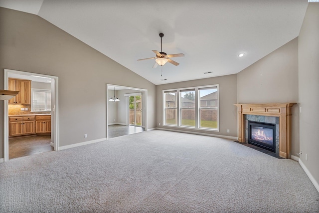 unfurnished living room with a ceiling fan, baseboards, carpet, a premium fireplace, and high vaulted ceiling