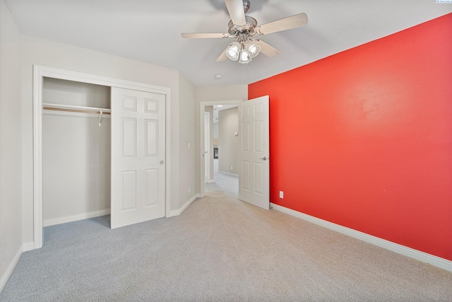 unfurnished bedroom with carpet floors, a closet, baseboards, and ceiling fan
