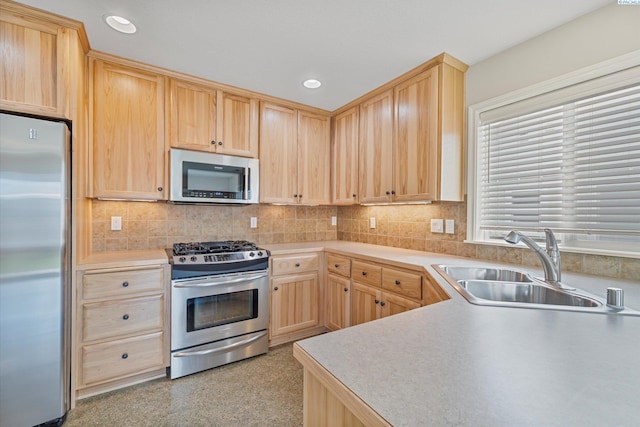 kitchen featuring stainless steel appliances, light brown cabinetry, a sink, light countertops, and recessed lighting