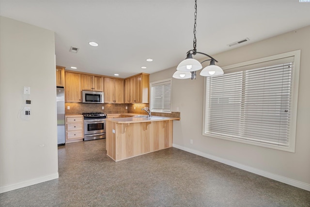 kitchen with appliances with stainless steel finishes, a sink, baseboards, tasteful backsplash, and recessed lighting