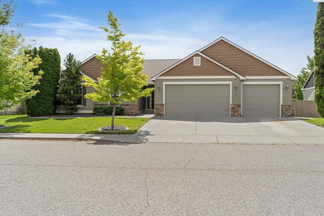 view of front facade featuring a garage, driveway, and stone siding