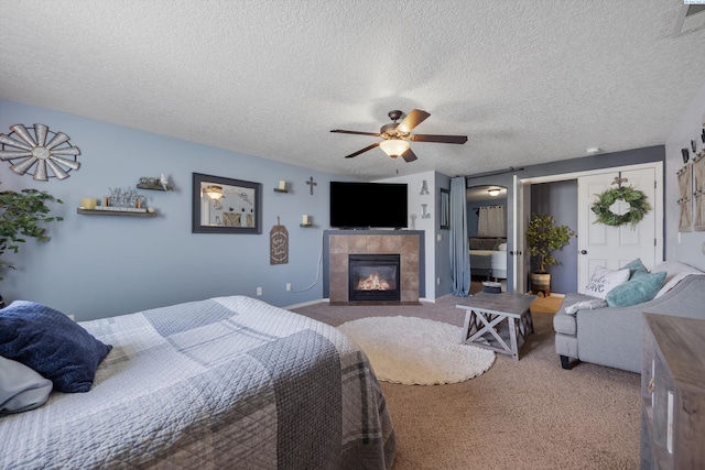 6115 Wildcat Ln, Pasco, WA 99301 - bedroom featuring ceiling fan, carpet floors, a tile fireplace, and a textured ceiling