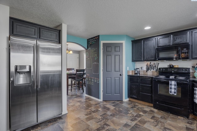 6115 Wildcat Ln, Pasco, WA 99301 - kitchen with a textured ceiling, black appliances, arched walkways, stone finish flooring, and baseboards