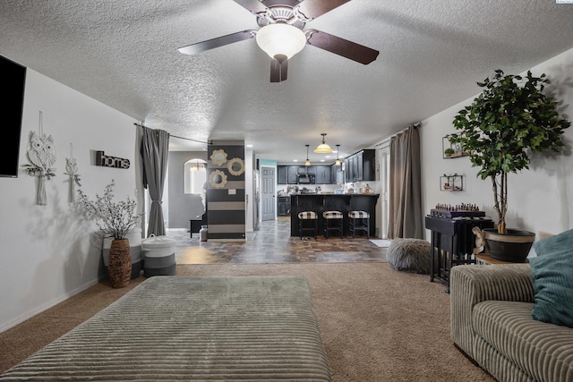 6115 Wildcat Ln, Pasco, WA 99301 - living room featuring a textured ceiling, carpet flooring, baseboards, and a ceiling fan