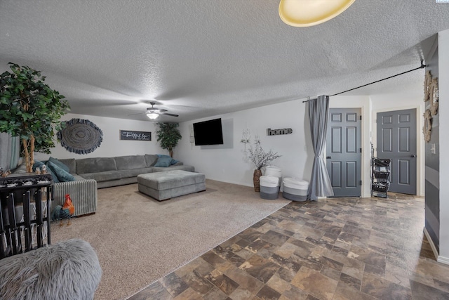 6115 Wildcat Ln, Pasco, WA 99301 - living room with a textured ceiling, baseboards, carpet, a ceiling fan, and stone finish floor