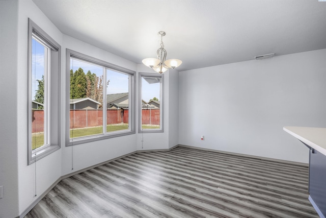 8307 Camano Dr, Pasco, WA 99301 - unfurnished dining area featuring a chandelier, wood finished floors, and plenty of natural light
