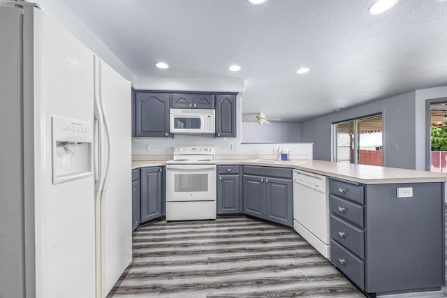 8307 Camano Dr, Pasco, WA 99301 - kitchen featuring white appliances, a peninsula, gray cabinets, light countertops, and a textured ceiling